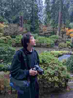 Kenneth in a garden looking up and taking photographs